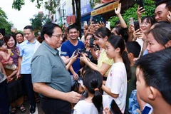 El primer ministro Pham Minh Chinh con los residentes del proyecto de vivienda social Thong Nhat. (Foto: VNA)