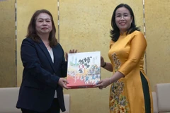 La vicepresidenta del Comité Popular de la ciudad vietnamita de Da Nang, Nguyen Thi Anh Thi, entrega obsequio a Satomi Iwashige, vicerrectora a cargo de estrategia y relaciones internacionales de la Universidad de la prefectura japonesa de Nagasaki. (Foto: VNA)