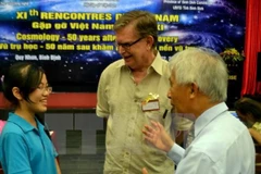 El astrofísico y cosmólogo estadounidense ganador del Premio Nobel de Física en 2006 George Fitzgerald Smoot y una estudiante vietnamita (Fuente: VNA)
