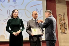 Nguyen Phan Bao Thuy, presidente de la UEVF, entrega la medalla conmemorativa "La boi", la más notable de la entidad, al embajador de Vietnam en Francia, Dinh Toan Thang. (Fuente: VNA)