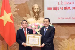 El presidente parlamentario Tran Thanh Man (derecha) entrega la insignia por 40 años de membresía del PCV a Nguyen Duc Hai, miembro del Comité Central del Partido y miembro del Comité de asuntos partidistas de la AN y vicepresidente del Parlamento. (Fuente:VNA)