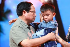 El primer ministro Pham Minh Chinh alentó a Nguyen Quoc Bao, quien perdió a su padre y su hermana mayor por las inundaciones en la comuna de Yen Thuan, distrito de Ham Yen, provincia de Tuyen. Quang. (Fuente:VNA)