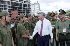 El presidente To Lam y miembros de la fuerza que participa en las tareas de protección de seguridad y orden a nivel de base de Ciudad Ho Chi Minh. (Fuente:VNA)