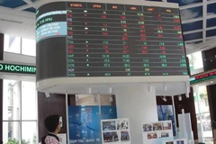 Los inversores monitorean las listas de precios de las acciones en la bolsa de valores de Ciudad Ho Chi Minh- HOSE (Fuente: VNA)
