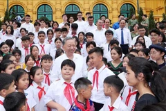 El presidente To Lam y los niños y delegados en el encuentro (Fuente: VNA)