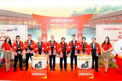 La cónsul general de Vietnam en Fukuoka Vu Chi Mai (tercera de la derecha), el gobernador de la prefectura de Hiroshima Yuzaki Hidehiko (cuarto de la derecha), el director general adjunto de Vietjet, Nguyen Duc Thinh (quinto de la derecha) y el presidente y director representante del Aeropuerto Internacional de Hiroshima, Yasuhiro Nakamura (quinto de la izquierda) junto con otros delegados en el escenario en la ceremonia para lanzar el primer vuelo que conecta Hiroshima y Hanoi. (Fuente: Vietjet)