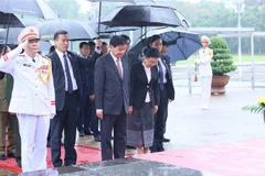 El secretario general del Partido Popular Revolucionario y presidente de Laos, Thongloun Sisoulith, su esposa y la delegación laosiana de alto rango rinden tributo al Presidente Ho Chi Minh. (Foto: VNA)