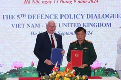 El viceministro de Defensa de Vietnam, el coronel general Hoang Xuan Chien, y el ministro de Estado de Defensa del Reino Unido, Vernon Coaker, firma el acta del diálogo. (Foto: VNA)