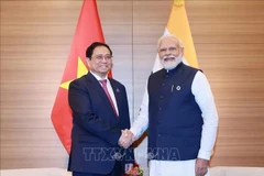 El primer ministro de Vietnam, Pham Minh Chinh (izquierda), y su homólogo indio, Narendra Modi, se reúnen en la Cumbre ampliada del G7 en Hiroshima, Japón, el 20 de mayo de 2023. (Foto: VNA)