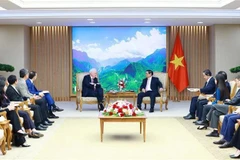 El primer ministro Pham Minh Chinh (centro, derecha) y Thomas Vallely, presidente del consejo directivo de la Universidad Fulbright de Vietnam, en su reunión en Hanoi el 17 de julio. (Foto: VNA)