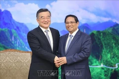 El primer ministro Pham Minh Chinh (D) y el vicepresidente del Comité Permanente de la Asamblea Popular Nacional (APN) de China, Zhang Qingwei. (Foto: VNA)