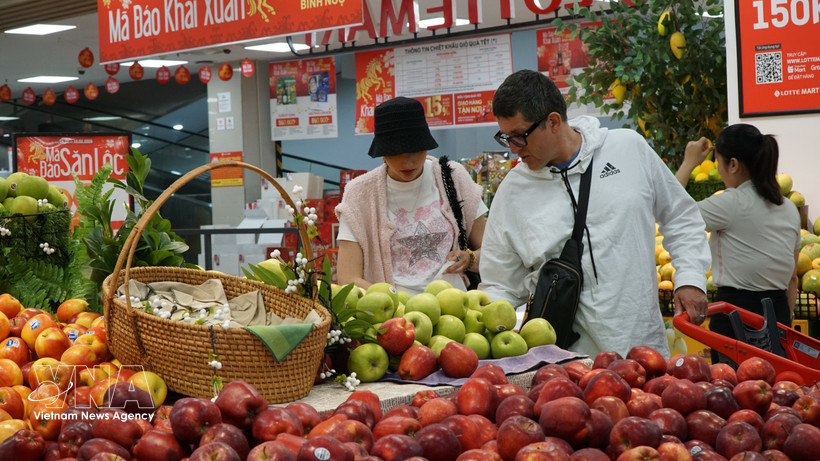 Extranjeros compran frutas en un mercado vietnamita. (Fuente: VNA)