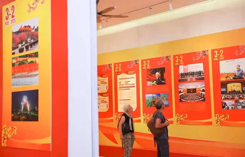 Turistas internacionales visitan una exposición por el aniversario 95 de la fundación del Partido Comunista de Vietnam. (Fuente: VNA)