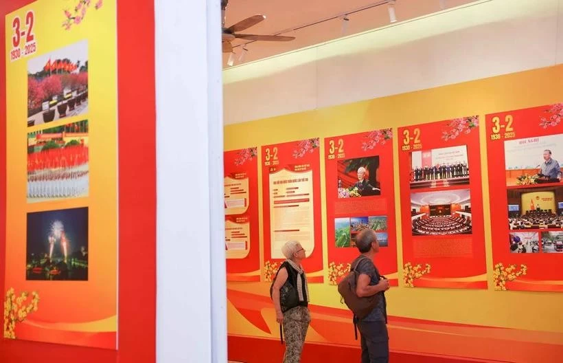 Turistas internacionales visitan una exposición por el aniversario 95 de la fundación del Partido Comunista de Vietnam. (Fuente: VNA)