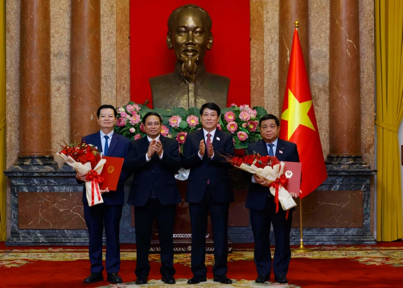 El presidente Luong Cuong entrega decisiones de nombramiento y el primer ministro Pham Minh Chinh entrega flores de felicitaciones a dos nuevos viceprimeros ministros de Vietnam. (Fuente: VNA)