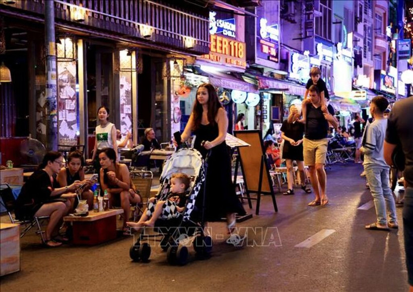 Turistas extranjeros pasean por la calle Bui Vien, en Ciudad Ho Chi Minh (Fuente: VNA)
