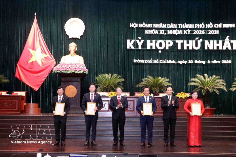 Tran Luu Quang (segundo de derecha), secretario del Comité municipal del Partido y Nguyen Duc Hai (tercero de izquierda) vicepresidente de la Asamblea Nacional, entrega decisión de reconocer a los delegados del Consejo Popular de la Ciudad. (Fuente: VNA)