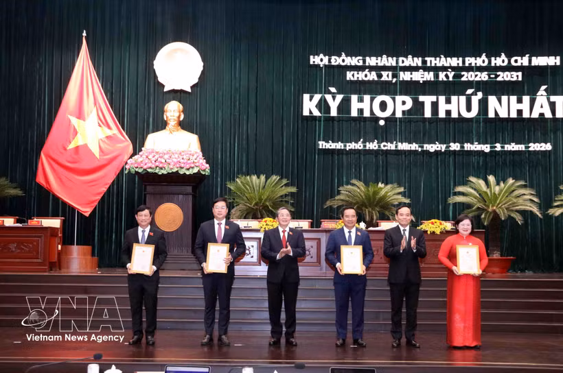Tran Luu Quang (segundo de derecha), secretario del Comité municipal del Partido y Nguyen Duc Hai (tercero de izquierda) vicepresidente de la Asamblea Nacional, entrega decisión de reconocer a los delegados del Consejo Popular de la Ciudad. (Fuente: VNA)