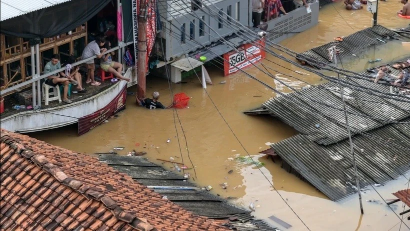 Una fotografía aérea muestra a personas en sus casas inundadas en el distrito de Pasar Minggu en Yakarta el 4 de marzo de 2025. (Foto: AFP)