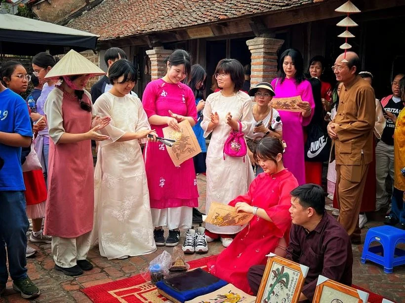 Turistas surcoreanos experimentan la elaboración de la pintura Dong Ho en el pueblo Duong Lam, Hanoi (Fuente: Vietnam+) 