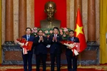 El presidente Luong Cuong entrega decisiones de nombramiento y el primer ministro Pham Minh Chinh entrega flores de felicitaciones a dos nuevos viceprimeros ministros de Vietnam. (Fuente: VNA)