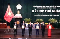 Tran Luu Quang (segundo de derecha), secretario del Comité municipal del Partido y Nguyen Duc Hai (tercero de izquierda) vicepresidente de la Asamblea Nacional, entrega decisión de reconocer a los delegados del Consejo Popular de la Ciudad. (Fuente: VNA)