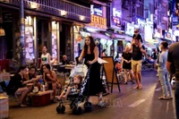 Turistas extranjeros pasean por la calle Bui Vien, en Ciudad Ho Chi Minh (Fuente: VNA)