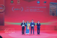El miembro del Buró Político y jefe de la Comisión de Propaganda, Educación y Movilización de Masas del Comité Central del Partido Comunista de Vietnam, Trinh Van Quyet, entrega el premio A a los galardonados. (Fuente: VNA)