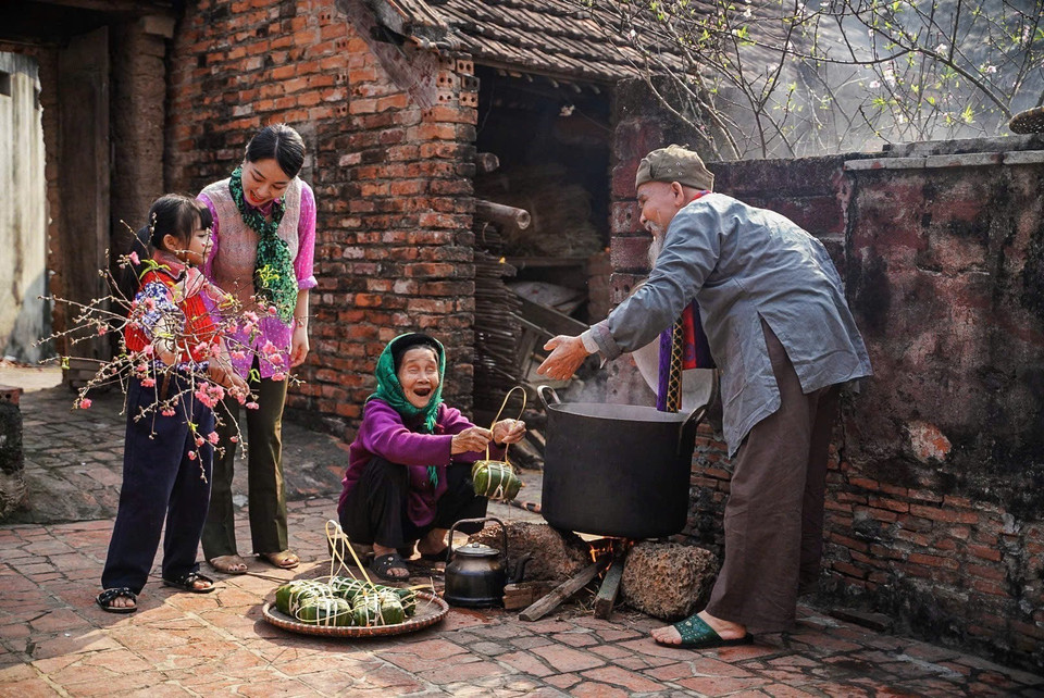 Generaciones de la familia se reúnen alrededor de la olla de banh chung (pastel redondo de arroz glutinoso). Foto: VNA