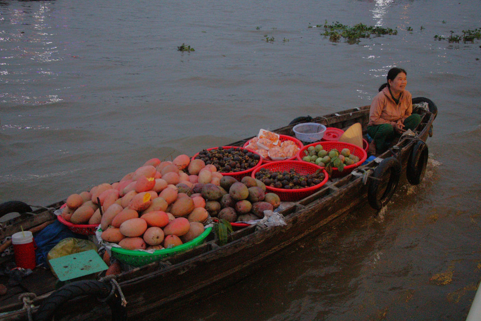 Productos agrícolas se transportan al mercado flotante para su venta al amanecer. Foto: VNA