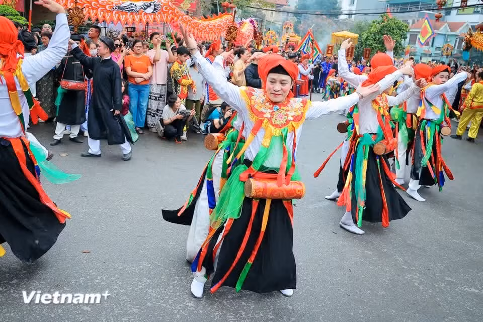 Con el rostro maquillado, labios carmesí y mejillas encendidas, vestidos como mujeres y con el tambor colgado al pecho, los bailarines realizan movimientos que mezclan coquetería con una precisa coordinación grupal. (Foto: Vietnam+)