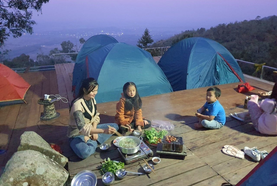 Una familia de turistas elige el homestay "Nha Cua May" en la cima de la montaña Cam para "vivir con calma". (Foto: VNA)