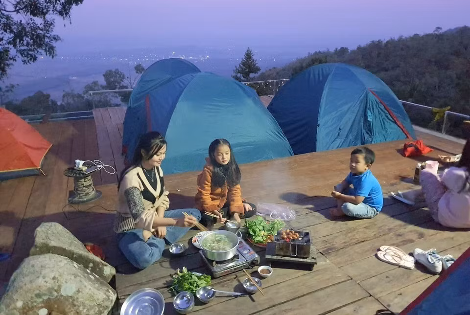 Una familia de turistas elige el homestay "Nha Cua May" en la cima de la montaña Cam para "vivir con calma". (Foto: VNA)