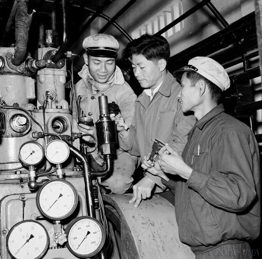 Expertos chinos (en el centro) instruyeron a trabajadores vietnamitas para desmontar y reparar válvulas automáticas de liberación de vapor en la planta de prensado K65 (septiembre de 1960). Foto: VNA