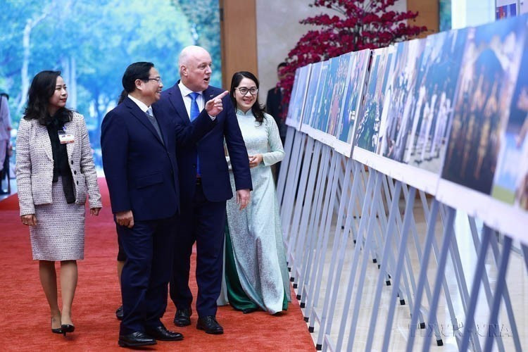 El primer ministro vietnamita, Pham Minh Chinh, y su homólogo neozelandés Christopher Luxon visitaron una exposición fotográfica sobre la cooperación entre ambos países, organizada por la VNA el 26 de febrero de 2025. Foto: VNA