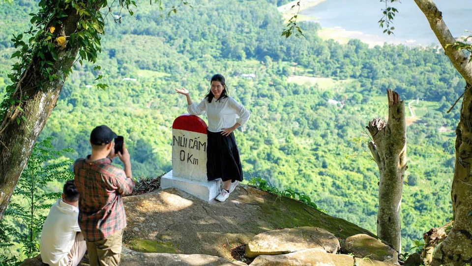 Turistas toman fotos frente al homestay “Thac Suoi Tien”, en la comuna de Nui Cam, provincia sureña de An Giang. (Foto: VNA)