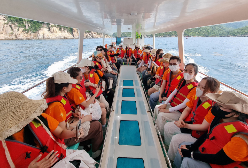 Los turistas toman un barco con fondo de cristal para visitar la bahía de Vinh Hy, en la comuna de Vinh Hai, provincia de Khanh Hoa. (Foto: VNA)