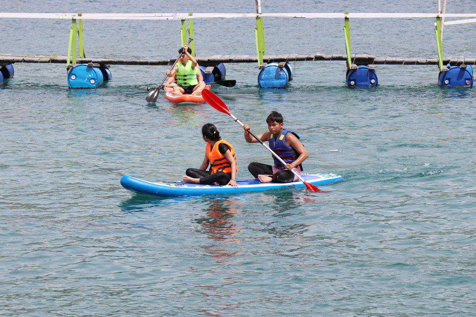 Los turistas experimentan la experiencia de remar en un bote en la bahía de Vinh Hy, en la comuna de Vinh Hai, provincia de Khanh Hoa. (Foto: VNA)