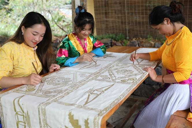 Mujeres de la etnia Lo Lo bordan brocados con meticulosidad, preservando la esencia de la artesanía tradicional y creando productos para el turismo comunitario. (Foto: VNA)