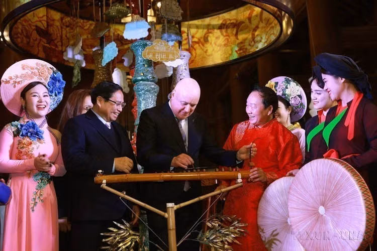 El primer ministro neozelandés, Christopher Luxon, y su homólogo vietnamita Pham Minh Chinh experimentaron con instrumentos musicales tradicionales vietnamitas durante su visita al Templo de la Literatura (Hanoi), el 27 de febrero de 2025). Foto: VNA