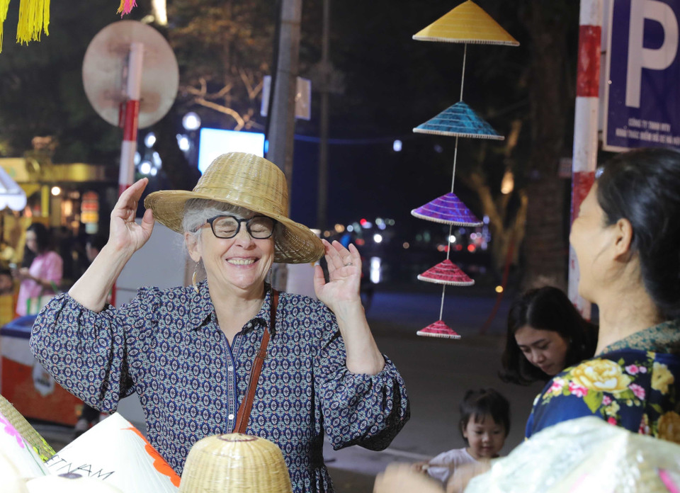 Visitantes internacionales disfrutan de productos tradicionales vietnamitas en el Festival de Regalos Turísticos de Hanoi 2025. (Foto: VNA)