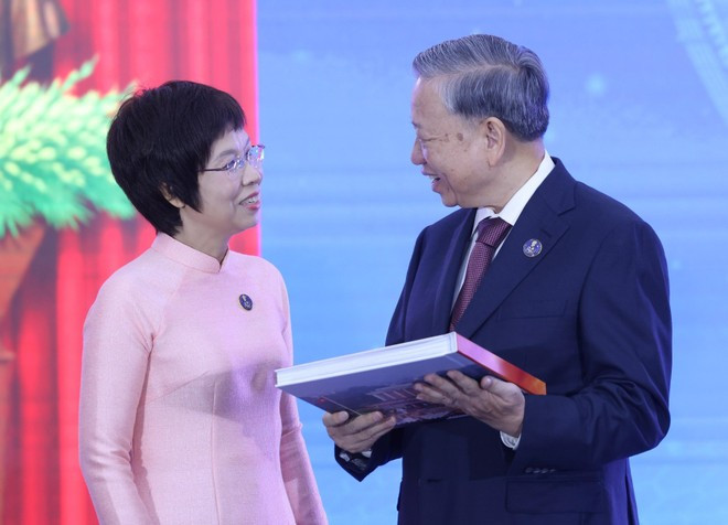 La directora general de VNA, Vu Viet Trang, entrega al secretario general To Lam el libro de fotografías «La gloria pertenece por siempre al pueblo». (Foto: VNA) vna-potal-tong-bi-thu-to-lam-du-le-ky-niem-80-nam-ngay-truyen-thong-thong-tan-xa-viet-nam-8274113.jpg