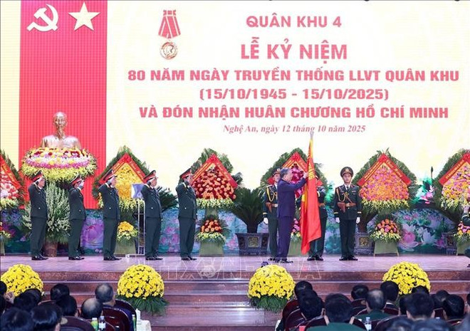 El secretario general del Partido Comunista de Vietnam, To Lam, impone la Orden Ho Chi Minh en la bandera tradicional de la Zona Militar 4. (Foto: VNA) tbt-gan-huan-chuong.jpg