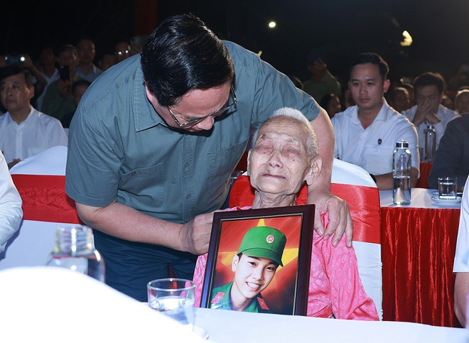 El primer ministro Pham Minh Chinh y una madre heroica. (Foto: VNA) vna-potal-thu-tuong-du-le-thap-nen-tri-an-cac-anh-hung-liet-si-tai-nghia-trang-liet-si-quoc-gia-truong-son-8173798.jpg