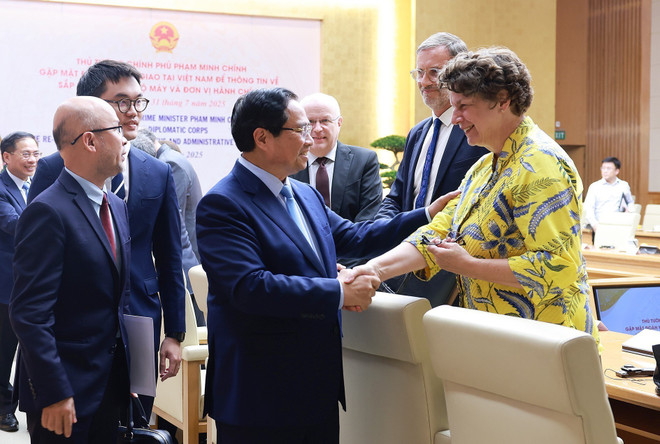 El primer ministro Pham Minh Chinh y los delegados en la reunión. (Foto: VNA) vna-potal-thu-tuong-thong-tin-ve-sap-xep-to-chuc-bo-may-va-don-vi-hanh-chinh-toi-doan-ngoai-giao-tai-viet-nam-8183424.jpg
