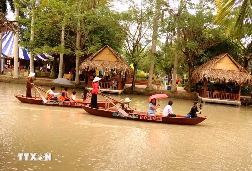Los turistas experimentan remar en el río en la aldea turística My Khanh, en la ciudad de Can Tho. (Fuente: VNA)