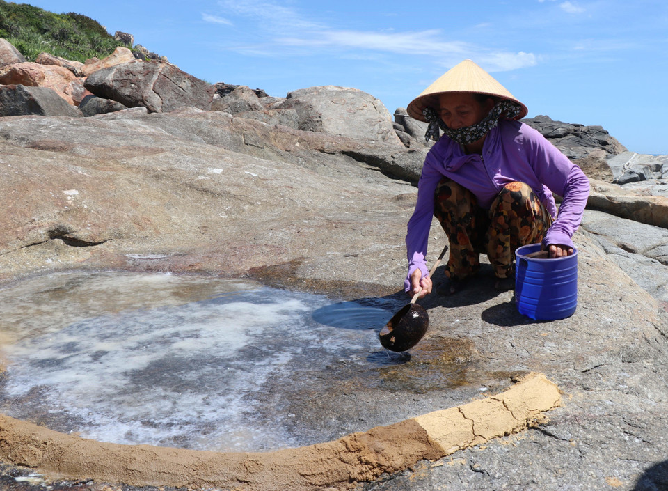 Los pobladores del barrio Co vierten agua marina en las rocas para aumentar el espesor de la sal. (Foto: VNA)