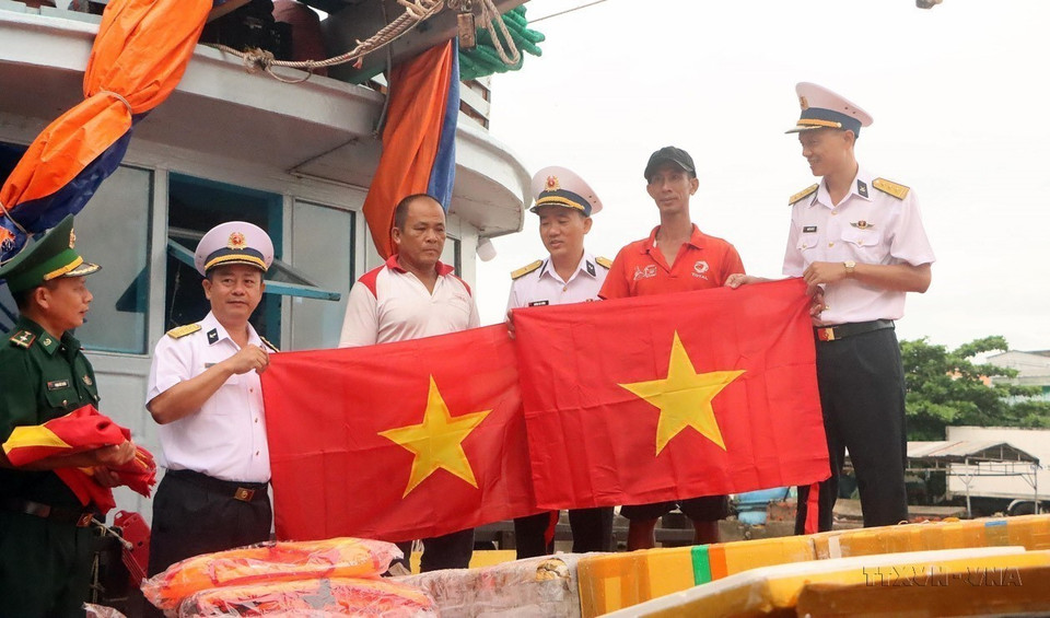 El Comando de la Región Naval 2 de la Armada Popular de Vietnam regala banderas a los pescadores de la provincia de Soc Trang, como parte de sus programas de apoyo a esas personas. (Foto: VNA)