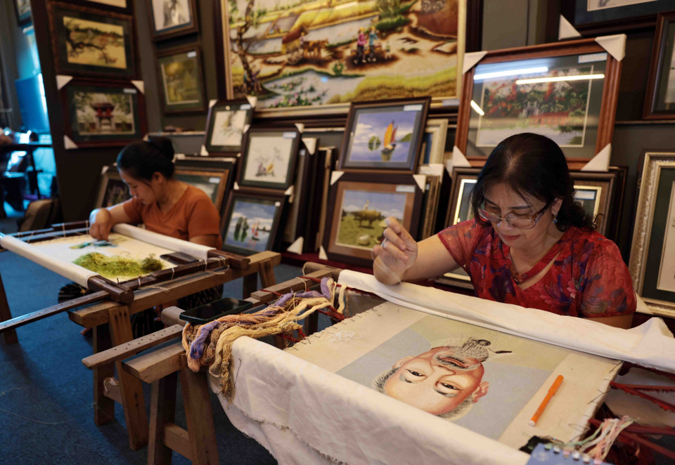 La artista Le Thi Xuan se empeña en elaborar el cuadro de bordado sobre el lago Hoan Kiem. (Foto: VNA)