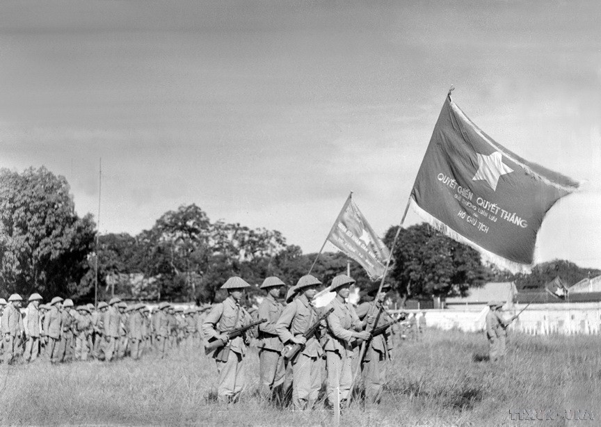 Una unidad de la División de la Capital, enarbolando la bandera “Determinación para luchar, determinación para vencer” entregada por el Presidente Ho Chi Minh realizó la primera ceremonia de izado de bandera después de la liberación de Hanoi, en el patio de Cot Co (Torre de la Bandera), actual puerta de Doan Mon de la Ciudadela Imperial de Thang Long. (Fuente: VNA)